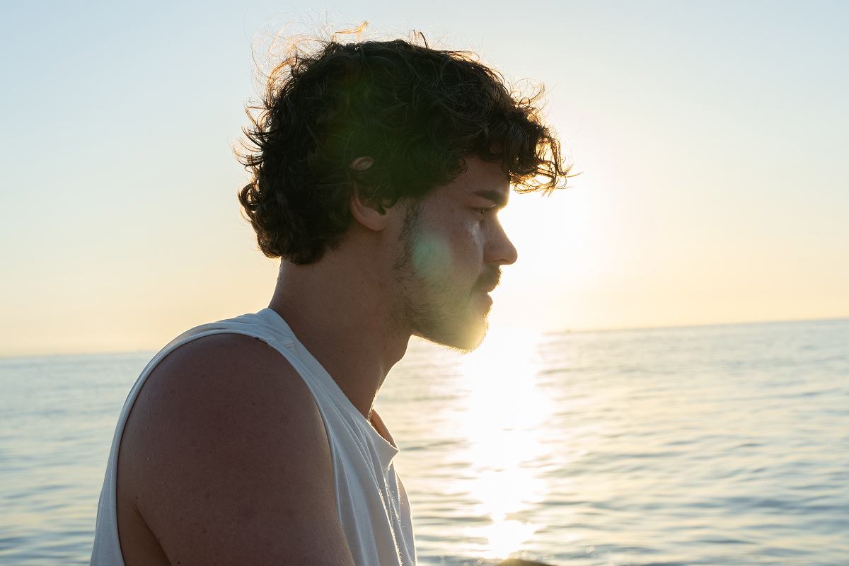 Man looking at a sunset, reflecting the harmony of body, breath, and expanded consciousness