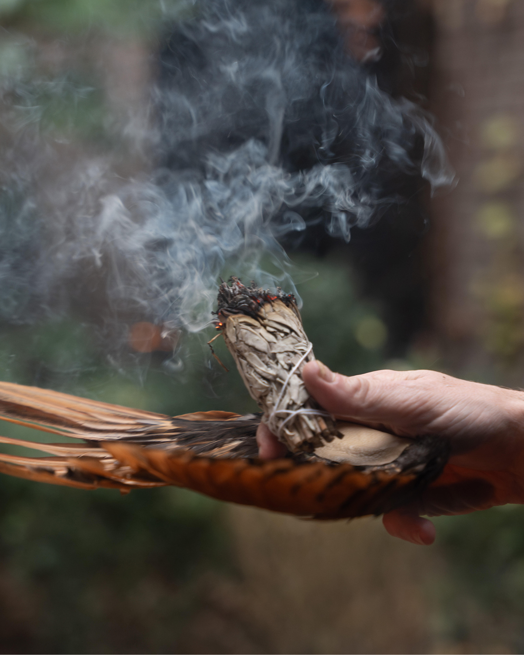 Relaxation and meditation: a woman relaxes on a mat in a sound therapy studio with lit candles, large gongs, and crystal singing bowls.